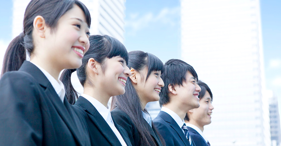 笑顔で佇むスーツ姿の男女